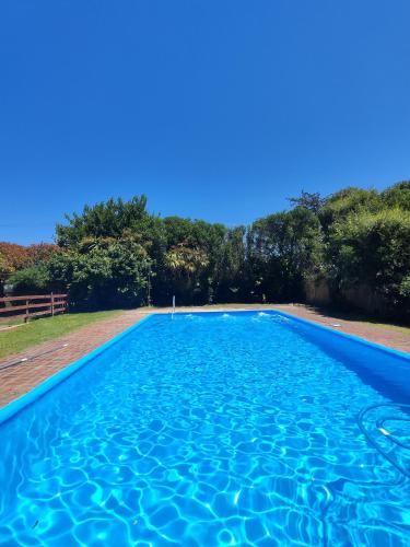 a blue swimming pool with trees in the background at La Posada del Mar in Miramar