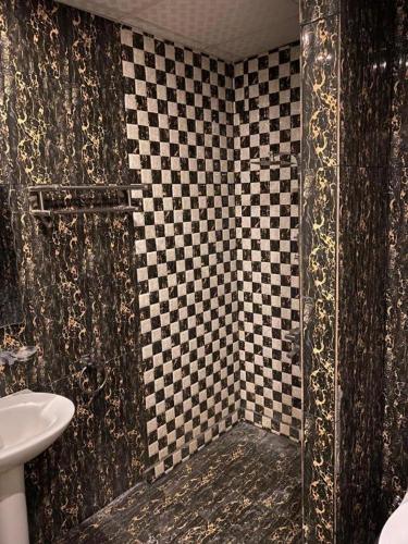 a bathroom with a black and white checkered shower at شعيل ان للشقق المخدومة - اقتصادي in Mecca