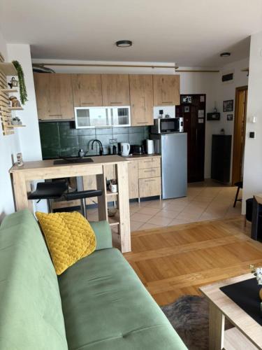 a living room with a couch and a kitchen at Apartman *Joy* in Osijek