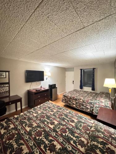 a hotel room with two beds and a flat screen tv at Executive Inn Coopersburg in Coopersburg
