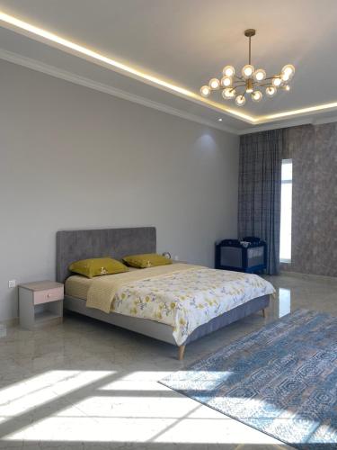 Falaj al Mu‘alláにあるمزرعه فلج المعلاのベッドルーム(キングサイズベッド1台、シャンデリア付)