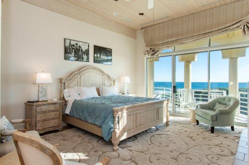 Chateau of the Isle by Emerald Isle Realty في Salter Path: غرفة نوم مع سرير وشرفه مع المحيط