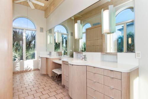 Chateau of the Isle by Emerald Isle Realty في Salter Path: حمام به مغسلتين ومرآة كبيرة