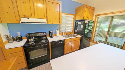 a kitchen with wooden cabinets and a black stove top oven at Circle 4 Condo 14 in Sunriver