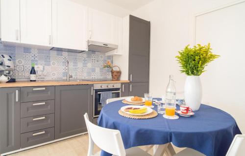 a kitchen with a blue table with food on it at Cozy Apartment In Marzamemi With Swimming Pool in Marzamemi