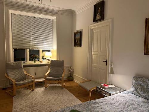 a bedroom with two chairs and a bed and a window at Topcity in Copenhagen