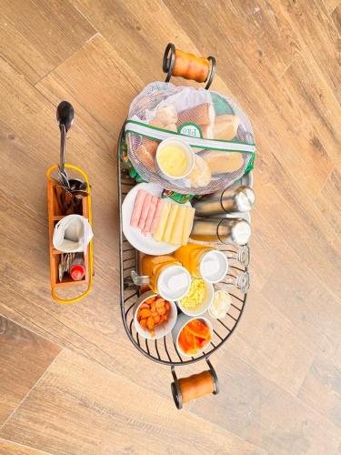 arolley filled with food on top of a wooden floor at Pousada Toa Toa Lavras Novas in Lavras Novas