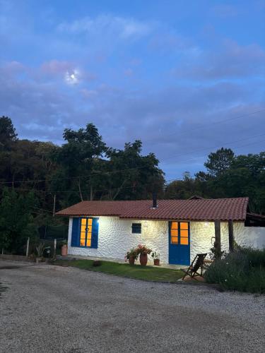 a small white house with blue and yellow doors at Sitio Lar da Terra in São Roque