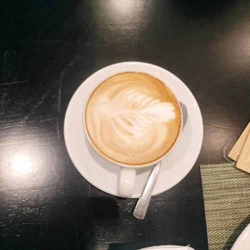 a cup of coffee on a plate on a table at N2 Village BnB in Hadi