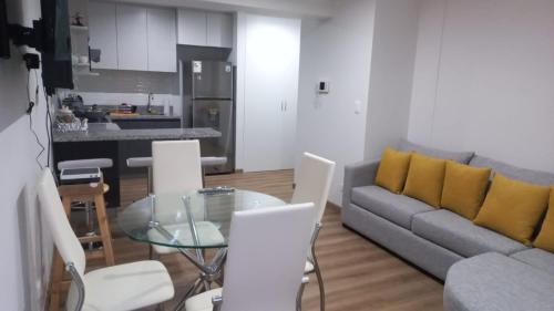 a living room with a couch and a glass table at Lovely & quiet place, park view & private parking in Lima