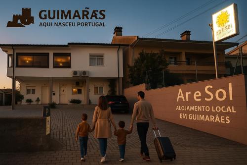 a family walking down a street with their luggage at Alojamento Ar e Sol in Guimarães