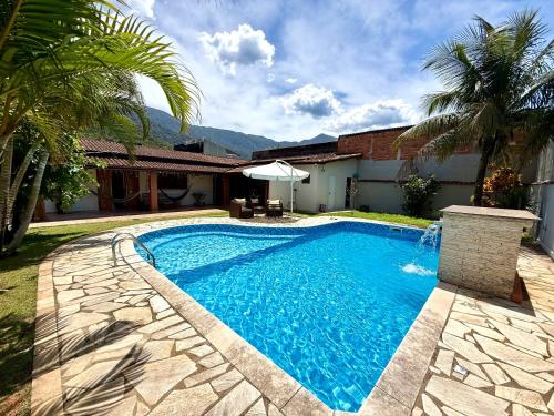 een zwembad voor een huis bij Casa com Espaço Gourmet e Piscina a 2min da Praia in Caraguatatuba