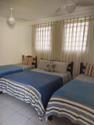 two twin beds in a room with windows at Espaço 579 in Miguel Pereira