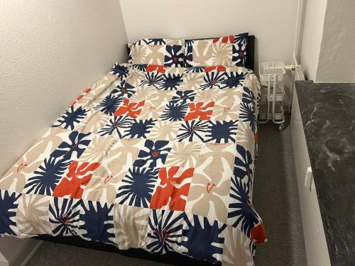 a bedroom with a bed with a blue and white quilt at Kiko in Horsens