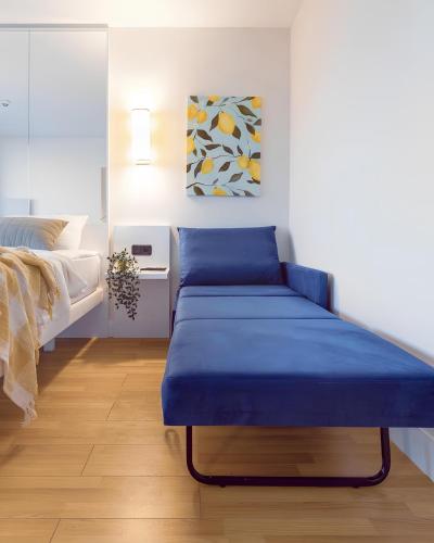 um banco azul num quarto com uma cama em Panorama Luxurious with sea view Hotel em Batumi