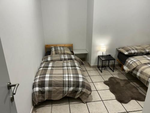 Un dormitorio con dos camas y suelo de baldosas. en Grâce à Liège, en Grâce-Hollogne