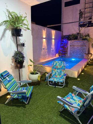 a patio with two chairs and a swimming pool at Loft's PB in Mérida