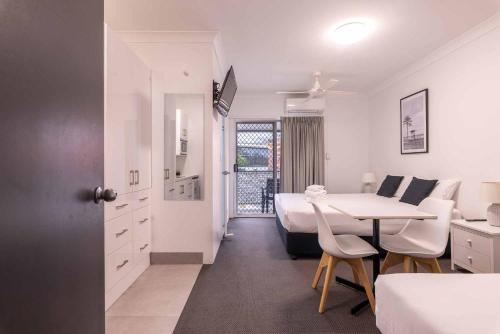 a white room with a bed and a table and a bedroom at Herston Place Motel in Brisbane