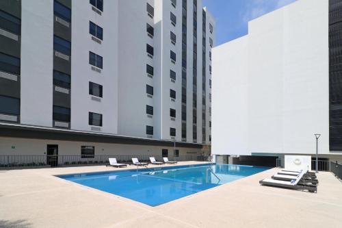 a swimming pool in front of a building at Holiday Inn & Suites Monterrey Apodaca Zona Airport, an IHG hotel in Monterrey
