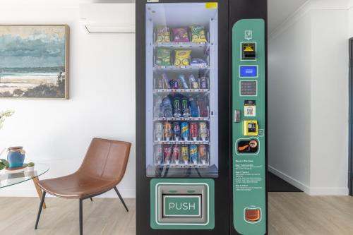 a drink vending machine in a room with a chair at Herston Place Motel in Brisbane