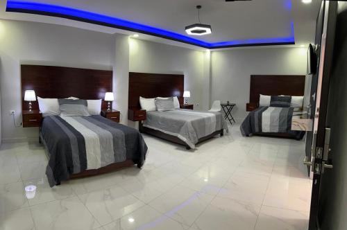 a room with two beds and a blue ceiling at Hotel New York in Santa Rosa de Copán