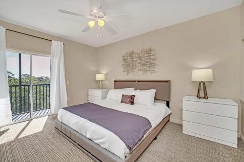 Un dormitorio con una cama y un ventilador de techo. en Upstay Modern 2BR Condo Near Disney, en Orlando