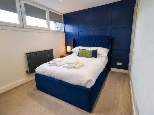een blauw bed met handdoeken in een kamer bij Highfield Cottage in Windermere