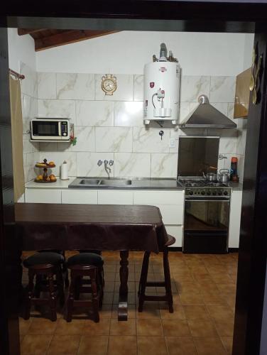 a kitchen with a table and two stools at CASA SILVIA NECOCHEA in Necochea