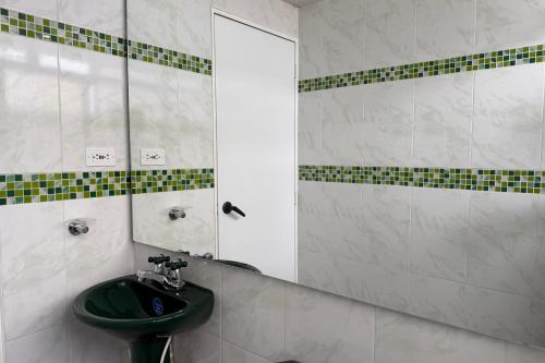 a bathroom with a green sink and a mirror at Increíble Apartamento En Sogamoso in Sogamoso