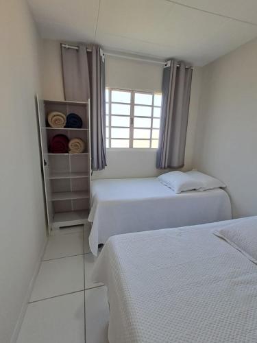 a bedroom with two beds and a window at Casa & lazer - Com piscina aquecida e churrasqueira in Garanhuns