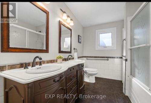 a bathroom with a sink and a toilet and a mirror at Luxurious home in Belleville in Bélanger