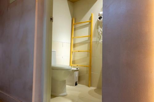 a bathroom with a toilet and a bathroom door open at Meraki Urban in Davao City