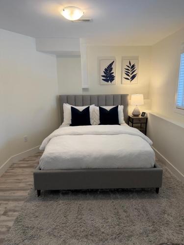a bedroom with a large bed with black and white pillows at Cozy Home Away from Home in Kingston