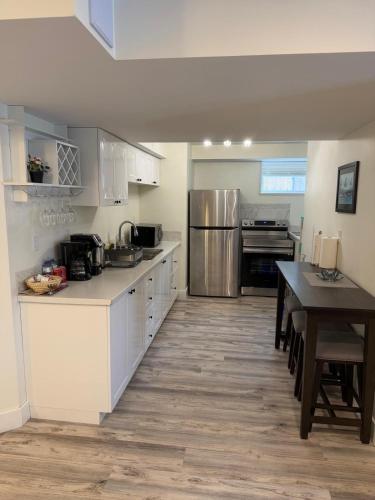 a kitchen with white cabinets and a table in it at Cozy Home Away from Home in Kingston
