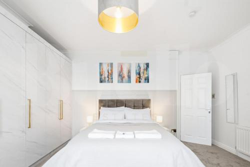 Ένα ή περισσότερα κρεβάτια σε δωμάτιο στο M5 Spacious Stylish Full Kitchen 2Bath Premium Beds Electric Sofa Recliners Smart TVs Netflix Underfloor Heating Instant Hot Water FastWifi