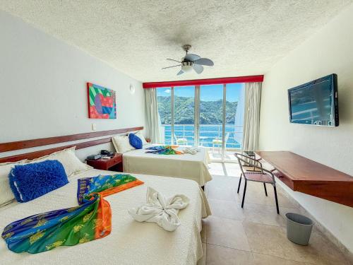 Hotel Bahia Taganga في تاجانجا: غرفة نوم بها سريرين ومكتب وتلفزيون