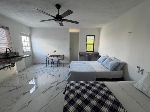 a bedroom with two beds and a ceiling fan at Loft's PB in Mérida