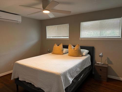 Un dormitorio con una cama con dos almohadas amarillas. en Stay Longer, Save 10 percent, Relax in Comfort 15, en Houston