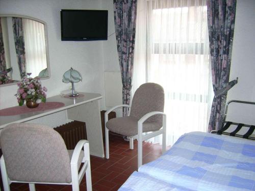 a bedroom with a bed and a desk and a mirror at Gästehaus Hochrhönblick in Schönau an der Brend