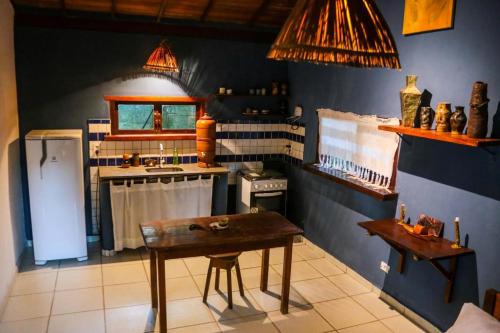 Ateliê Cultural Trancoso في ترانكوسو: مطبخ مع طاولة خشبية وموقد