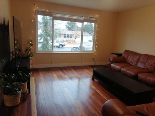 a living room with a couch and a large window at Beautiful home with your own entrance in Sandy in Sandy