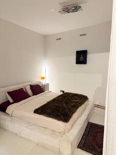 una camera bianca con un grande letto con una coperta marrone di Casa Mia Terra Loft ad Anversa