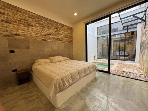 Villa Zamora 52 Coatepec Centro في كواتيبيك: غرفة نوم بها سرير وجدار من الطوب