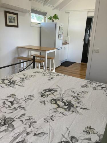 a bedroom with a bed and a table and a refrigerator at The Little House in Golden Square