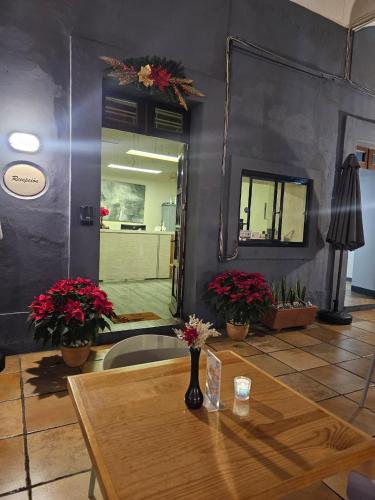 a room with a table and a mirror and flowers at BKL Hotel Oaxaca in Oaxaca City