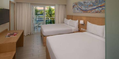 Junior Suite all inclusive luxury and tranquility by Lifestyle Resort في Maggiolo: غرفة فندقية بسريرين وشرفة