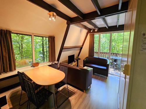 Habitación con mesa, silla y escritorio. en Charming chalet in Durby with patio, en Septon