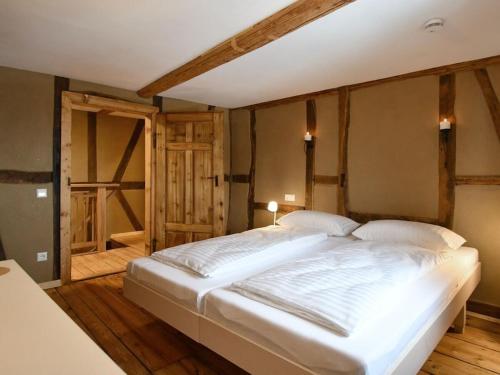 Cette chambre comprend un grand lit blanc et du parquet. dans l'établissement Ferienhaus Steffens, à Mörz
