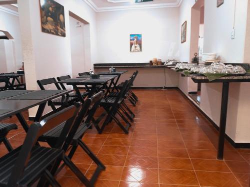 a dining room with tables and chairs and a counter at Hotel Minas Brasil in Salinas