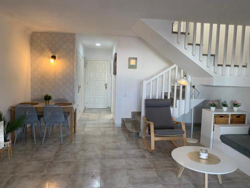 un soggiorno con una scala, un tavolo e delle sedie di Casa 3 Soles a Morro del Jable